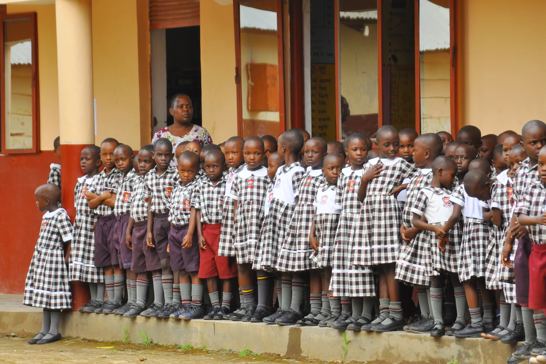 A class of young pupils lined up in front of the building
